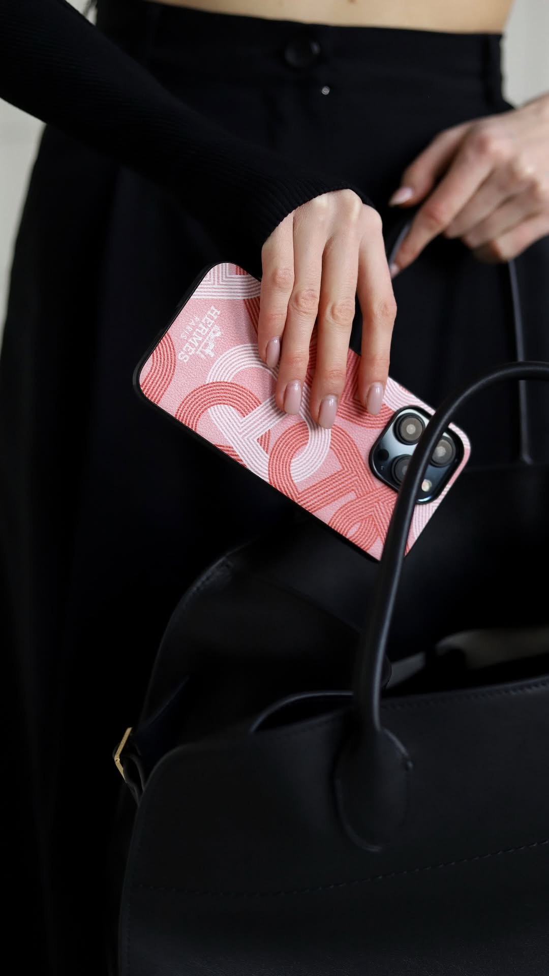 Hermes iPhone 16 Pro Max case with repeating H-pattern in pink, with a black border.