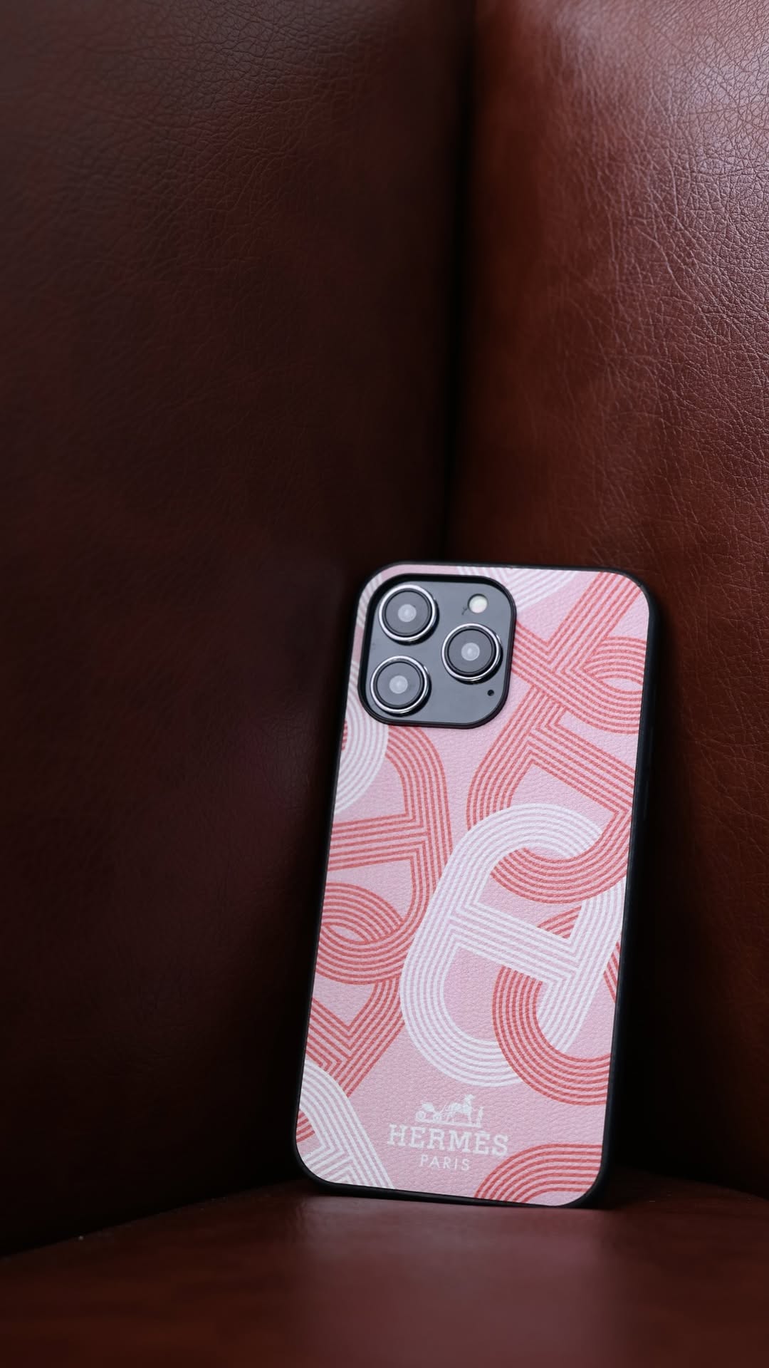 Hermes iPhone 16 Pro Max case with repeating H-pattern in pink, with a black border.