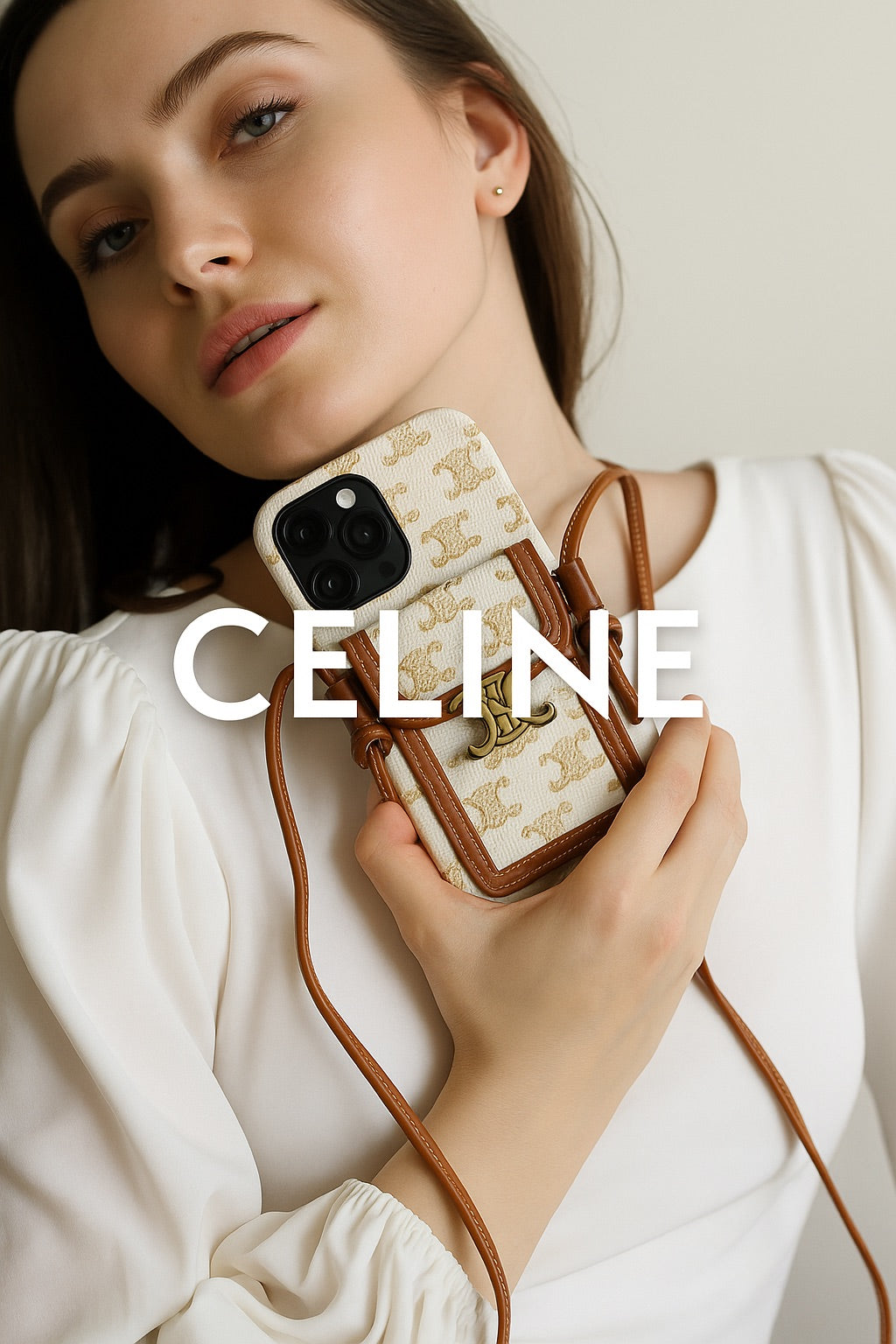 Young woman holding a Celine-inspired crossbody iPhone 16 Pro Max case with white and tan leather finish, luxury gold emblem, styled in soft natural light with elegant minimalist fashion.